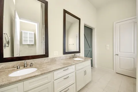a bathroom with double sink and a mirror