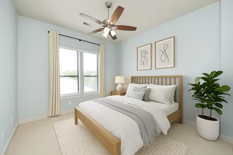 a bedroom with a large bed and a potted plant