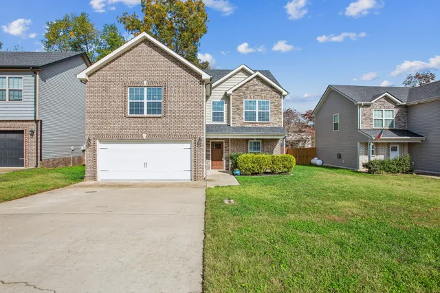a front view of a house with a yard and garage