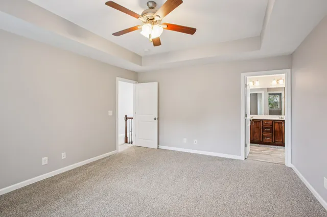 an empty room with closet and a chandelier fan