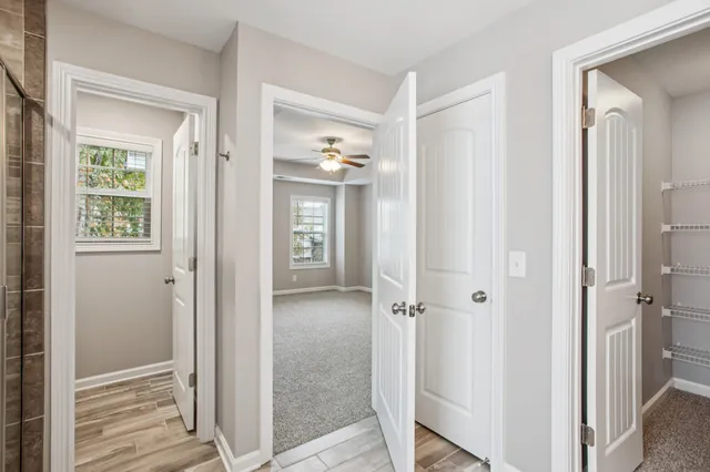 a view of a bathroom with wooden floor and mirror