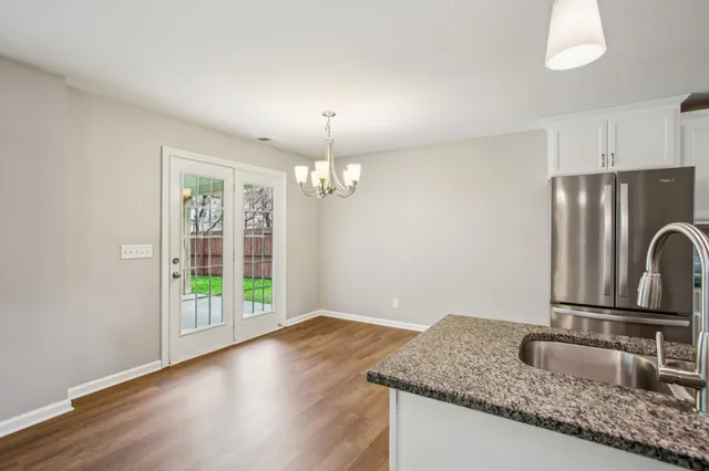 a kitchen with granite countertop a sink cabinets and wooden floor