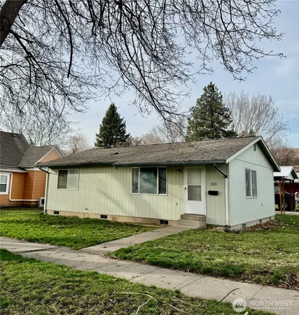a house with green field in front of it
