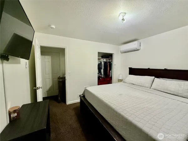 a bedroom with a bed and a flat screen tv