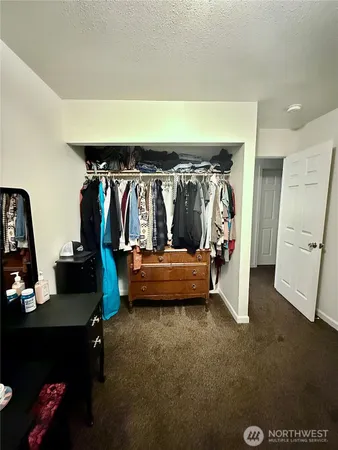 a view of walk in closet with clothes and shoes