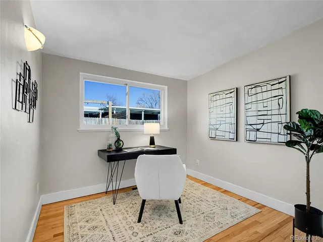 a view of a workspace with furniture and a window