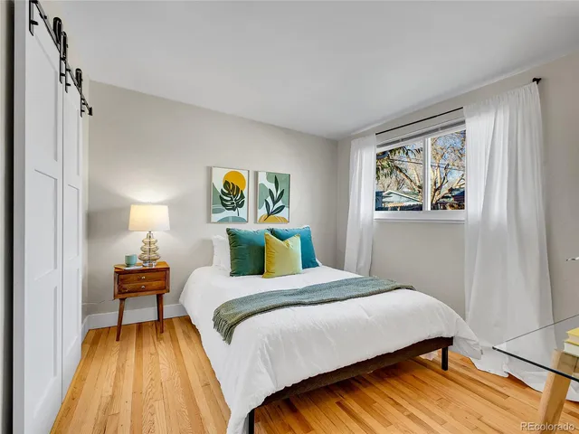 a bedroom with a bed and wooden floor