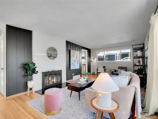 a living room with furniture potted plant a fireplace and a window