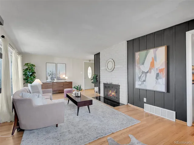 a living room with furniture a fireplace and a large window
