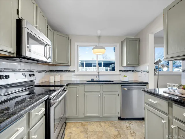a kitchen with a sink stove top oven and microwave
