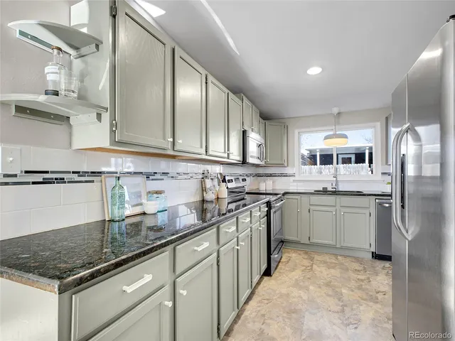 a kitchen with stainless steel appliances granite countertop a sink stove and refrigerator