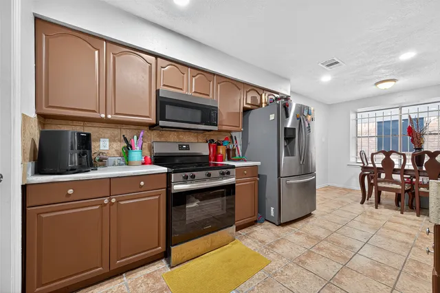 a kitchen with stainless steel appliances granite countertop a refrigerator stove top oven and sink