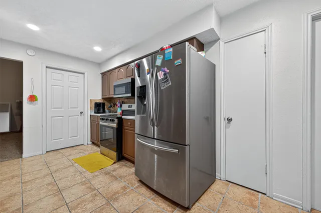 a kitchen with stainless steel appliances granite countertop a refrigerator and a sink