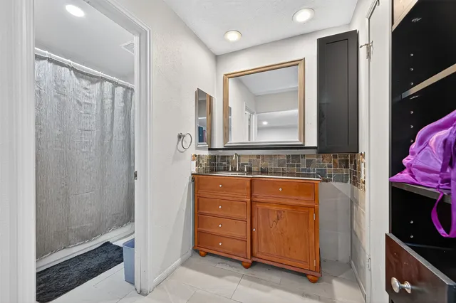 a bathroom with a granite countertop sink a mirror and a shower