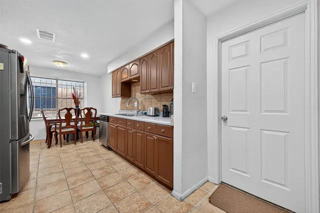 a kitchen with stainless steel appliances granite countertop a refrigerator and a sink
