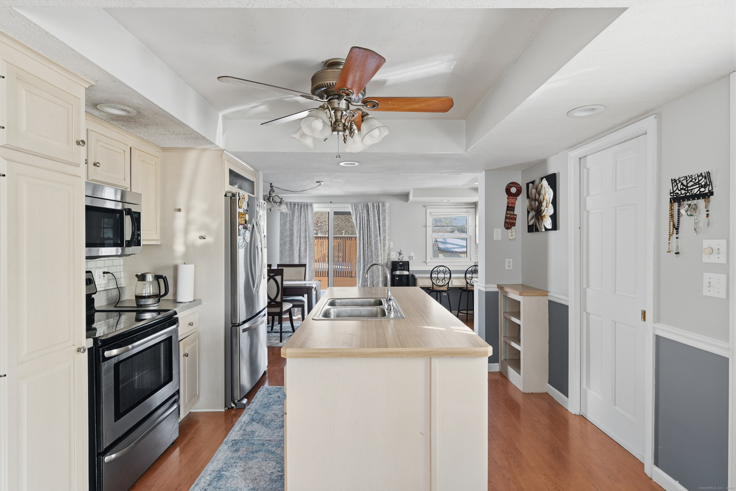 103 Benham Street Bristol, CT 06010 - Photo 9 of 39 a kitchen with stainless steel appliances kitchen island granite countertop a refrigerator a stove a sink a dining table and chairs with wooden floor