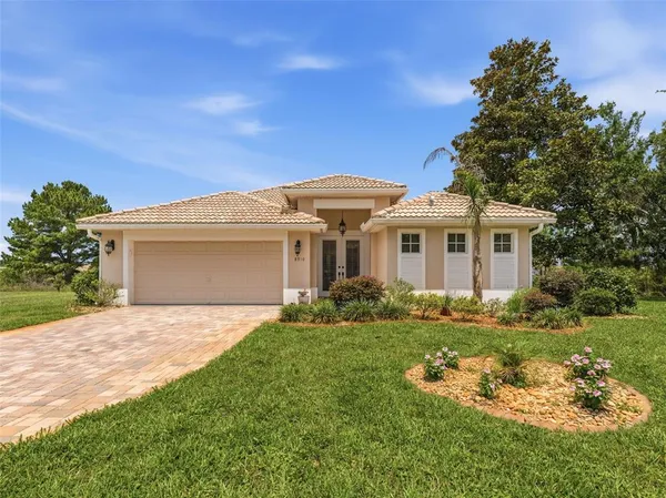 a front view of a house with a garden and yard