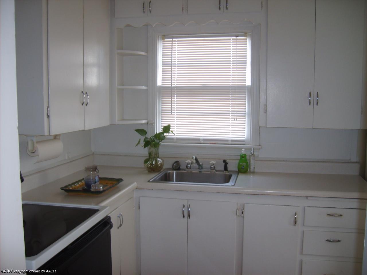 4011 South Jackson Street Amarillo, TX 79110 - Photo 2 of 10 a kitchen with white cabinets and a window