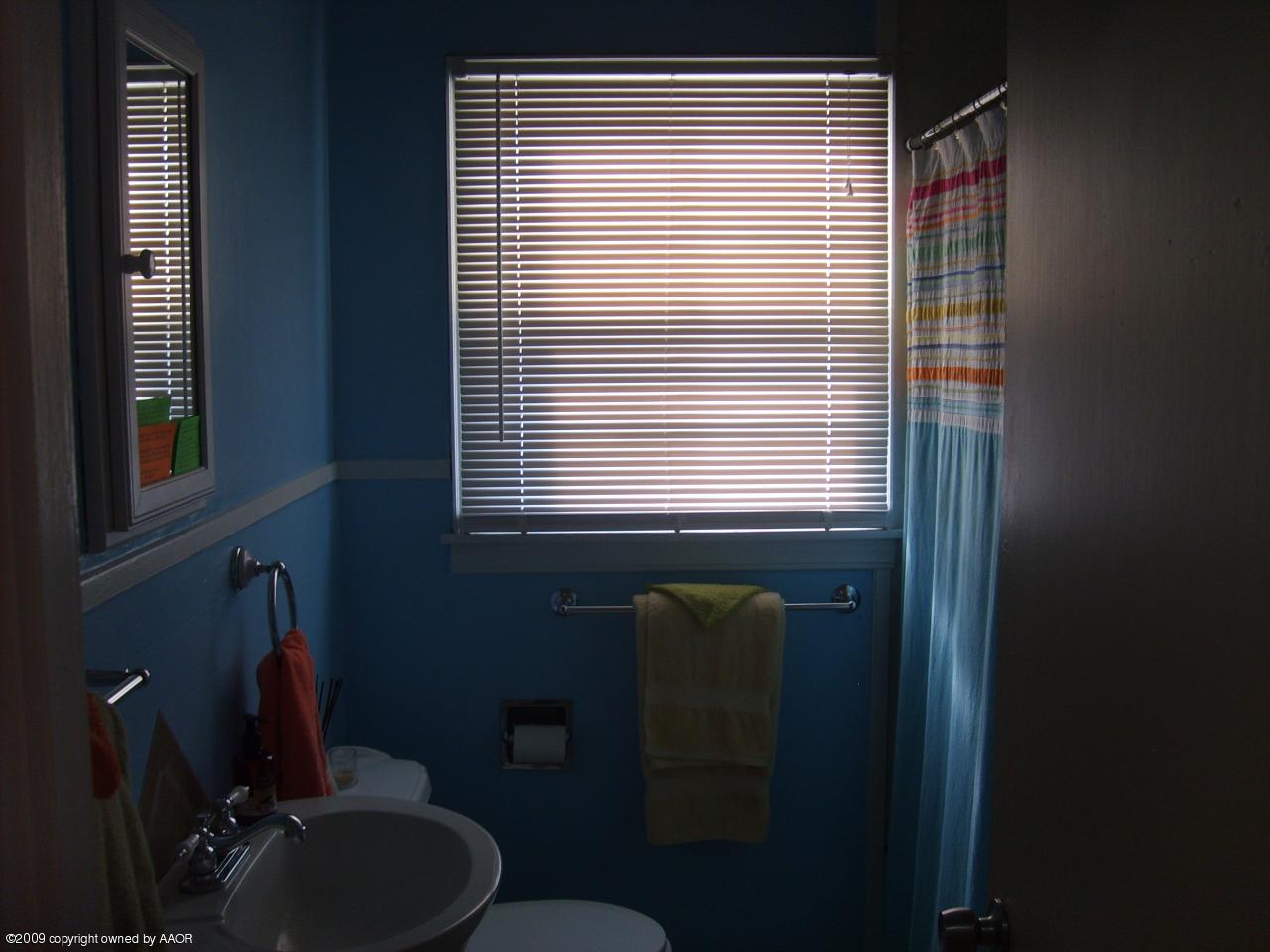 4011 South Jackson Street Amarillo, TX 79110 - Photo 8 of 10 a bathroom with a sink and a mirror
