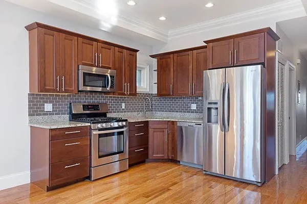 a kitchen with stainless steel appliances granite countertop a refrigerator stove a sink and a microwave