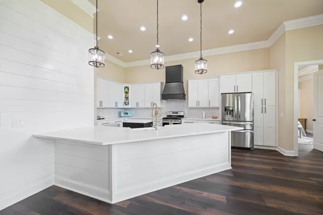a kitchen with stainless steel appliances granite countertop a sink a stove and a wooden floors