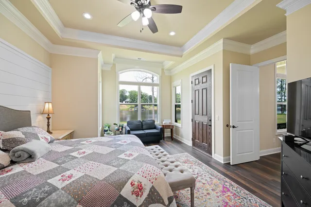 a bedroom with a bed a flat screen tv and a large window
