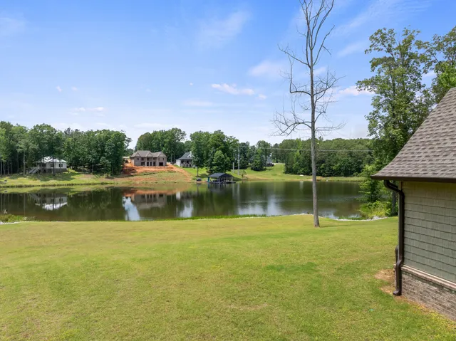 a view of a lake with a big yard potted plants and wooden floor