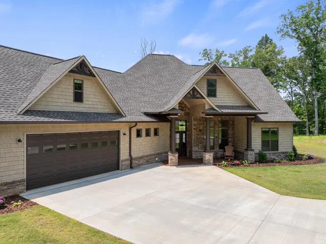 a front view of a house with a garden and trees