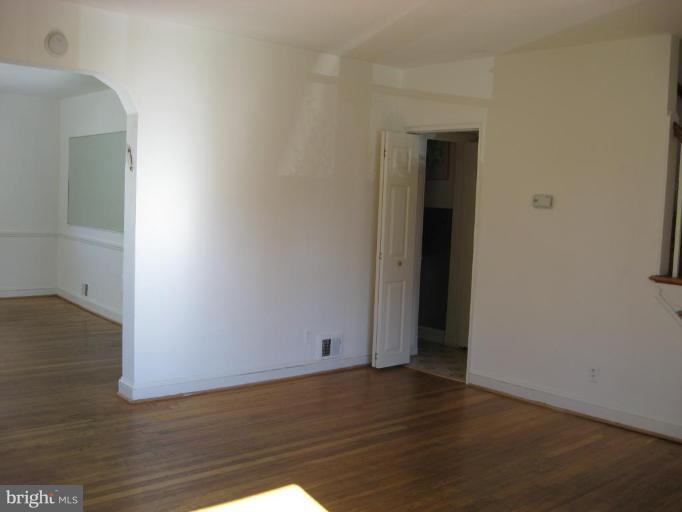 6923 Fieldcrest Road Baltimore, MD 21215 - Photo 3 of 10 an empty room with wooden floor and closet