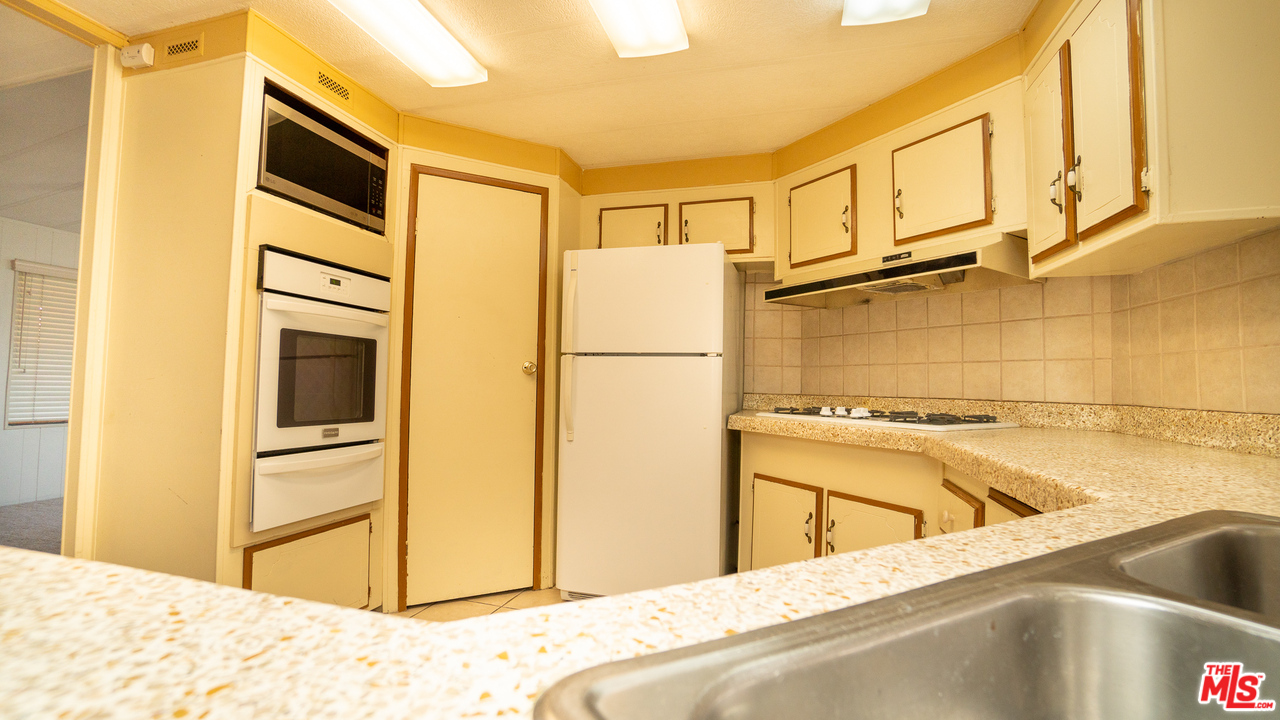 17701 South Avalon Boulevard, Unit 147 Carson, CA 90746 - Photo 5 of 28 a view of a kitchen with a sink and refrigerator