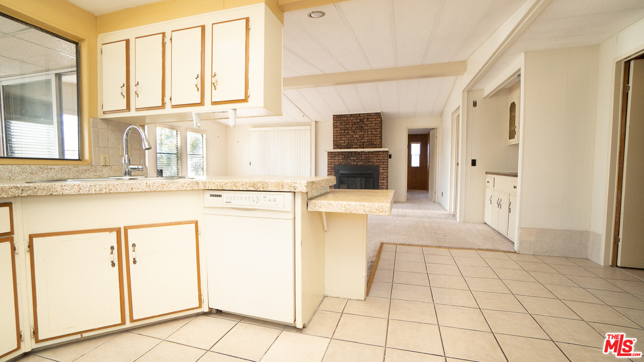 17701 South Avalon Boulevard, Unit 147 Carson, CA 90746 - Photo 8 of 28 a kitchen with granite countertop a sink a stove a refrigerator and white cabinets