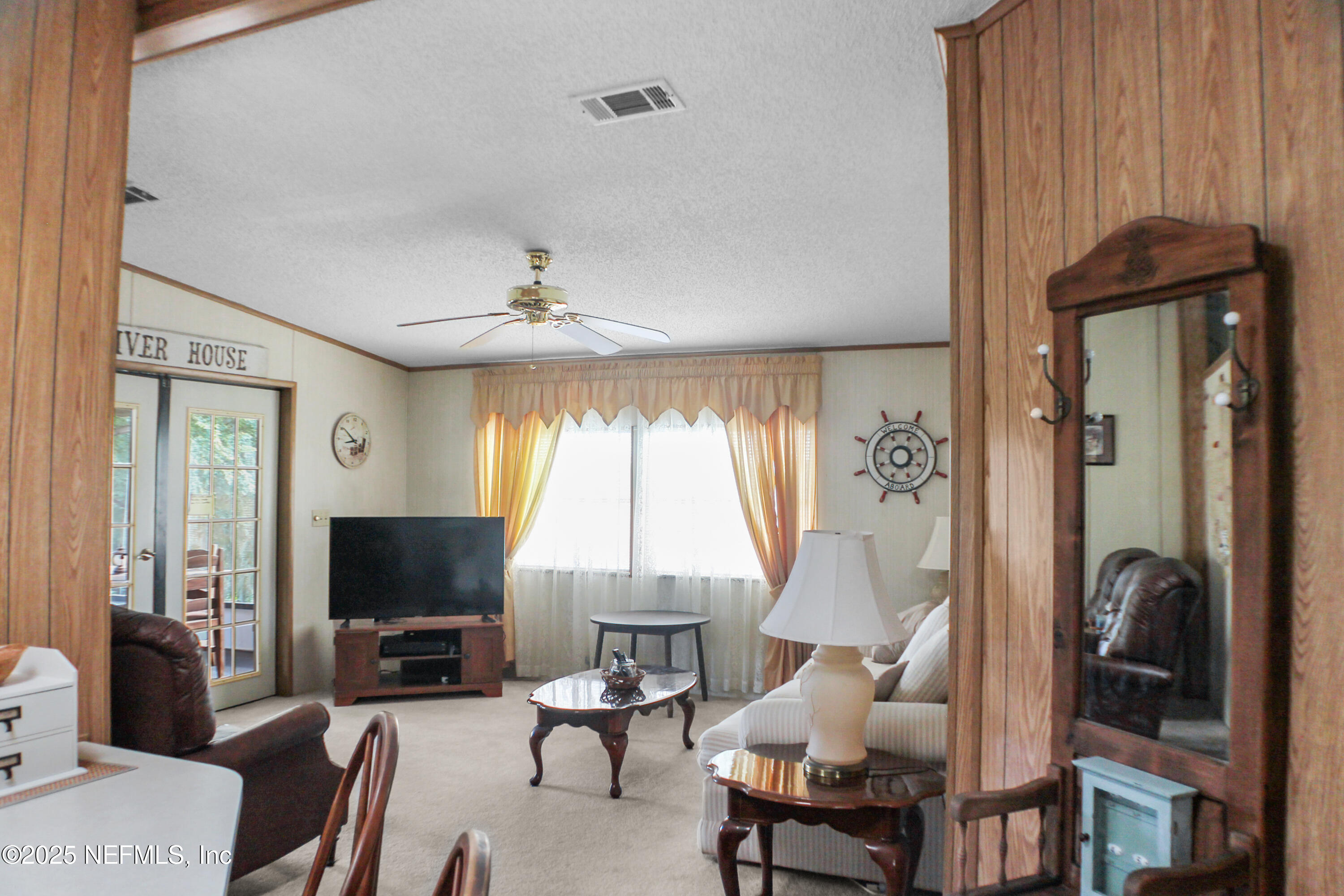 134 Magnolia Street Satsuma, FL 32189 - Photo 7 of 62 a living room with furniture a flat screen tv and a large window