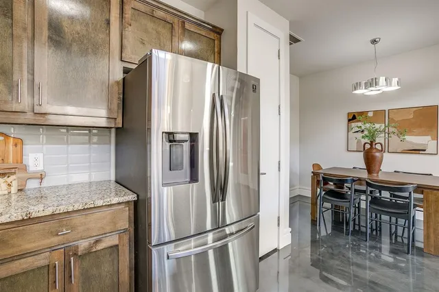 a kitchen with stainless steel appliances granite countertop a refrigerator and a stove top oven