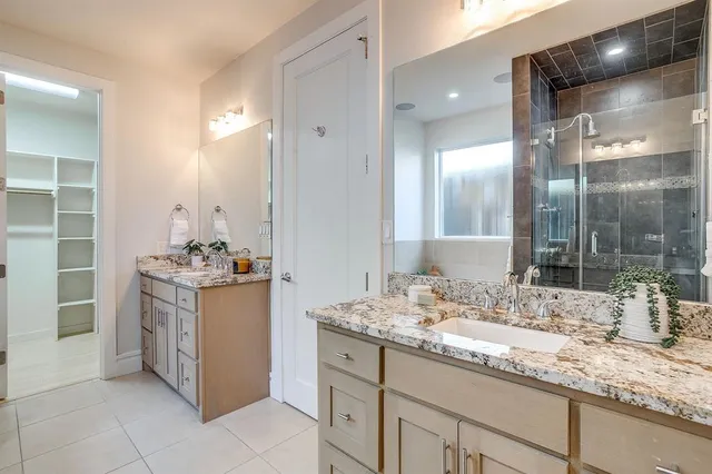 a bathroom with a granite countertop sink a mirror and a shower