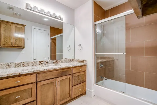 a bathroom with a sink double vanity granite tub and shower