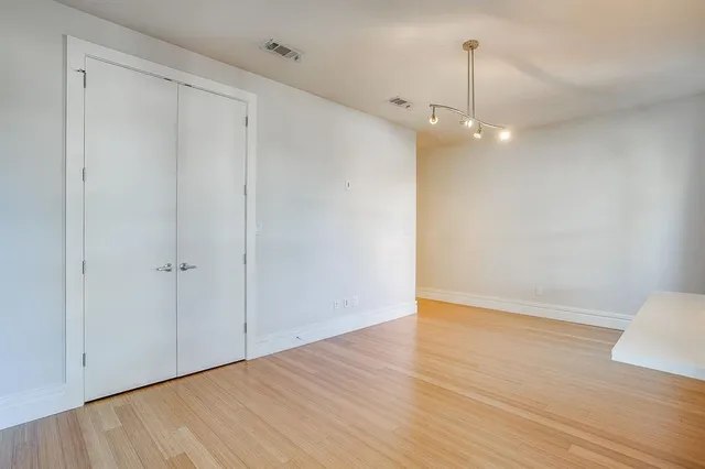 a view of an empty room with wooden floor