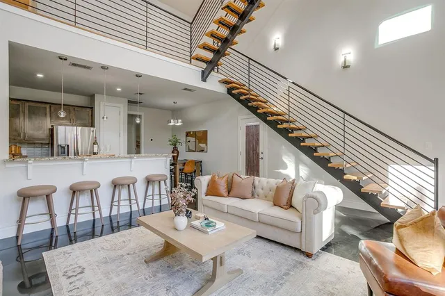 a living room with lots of furniture and view of kitchen