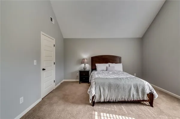 a bedroom with a bed a couch and a flat tv screen