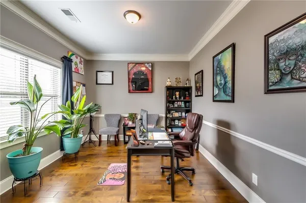 a living room with furniture potted plant and wooden floor