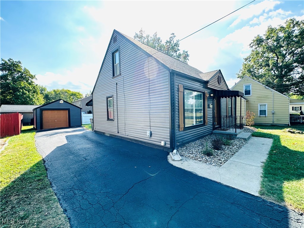 3727 Hopkins Road Youngstown, OH 44511 - Photo 11 of 40 View of home's exterior with an outdoor structure, a garage, and a yard