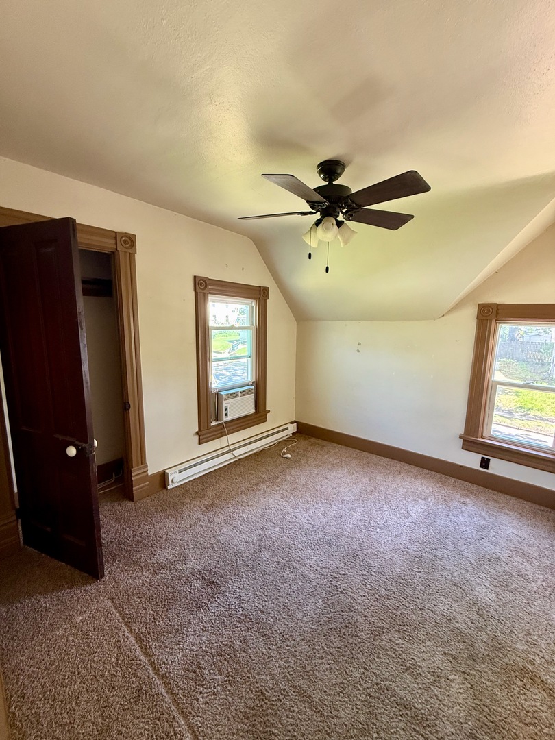 913 West 4th Street Dixon, IL 61021 - Photo 5 of 8 an empty room with windows and ceiling fan