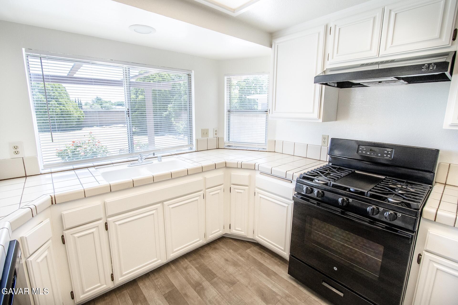 44318 33rd Street West Lancaster, CA 93536 - Photo 11 of 29 a kitchen with granite countertop a stove and a sink