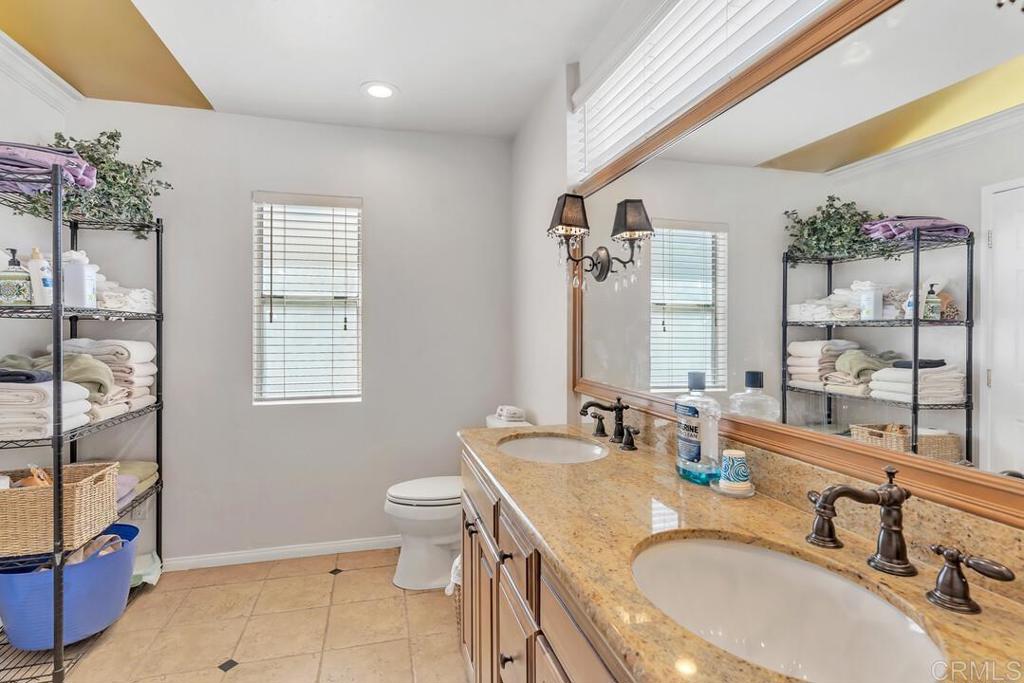 10447 Cadwell Road Santee, CA 92071 - Photo 19 of 32 a bathroom with a granite countertop sink a toilet a mirror and shower