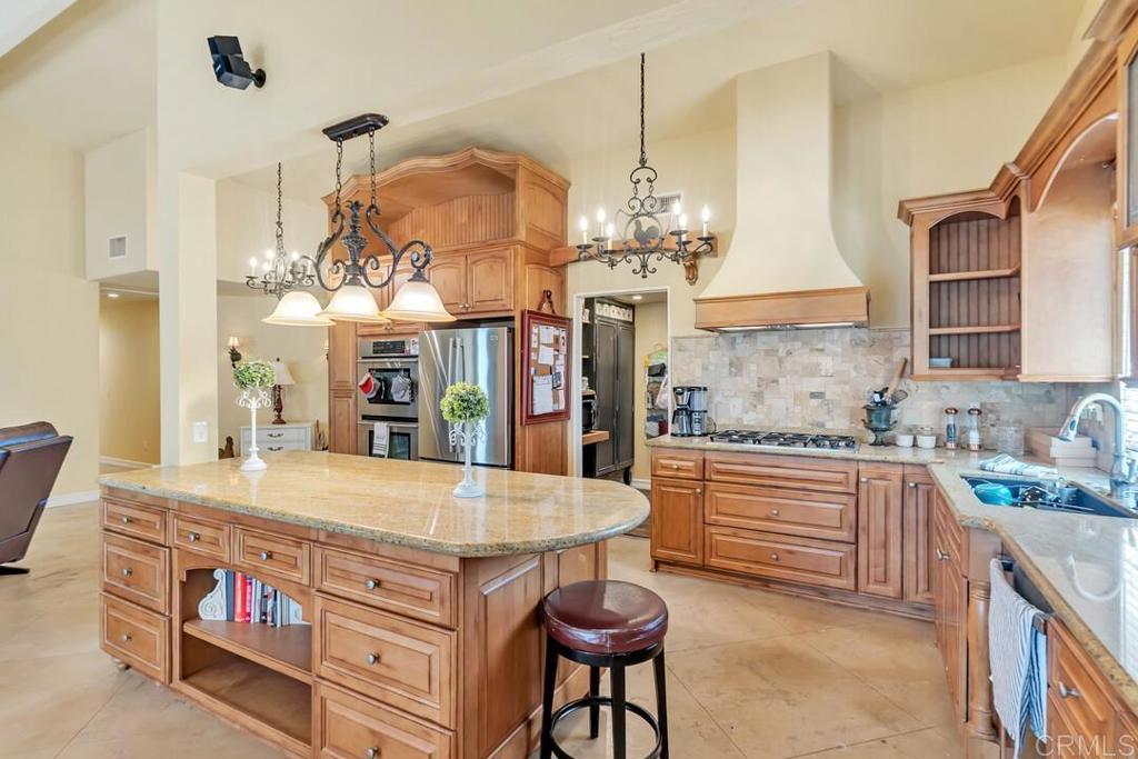 10447 Cadwell Road Santee, CA 92071 - Photo 6 of 32 a kitchen with stainless steel appliances granite countertop a kitchen island a stove a table and chairs in it