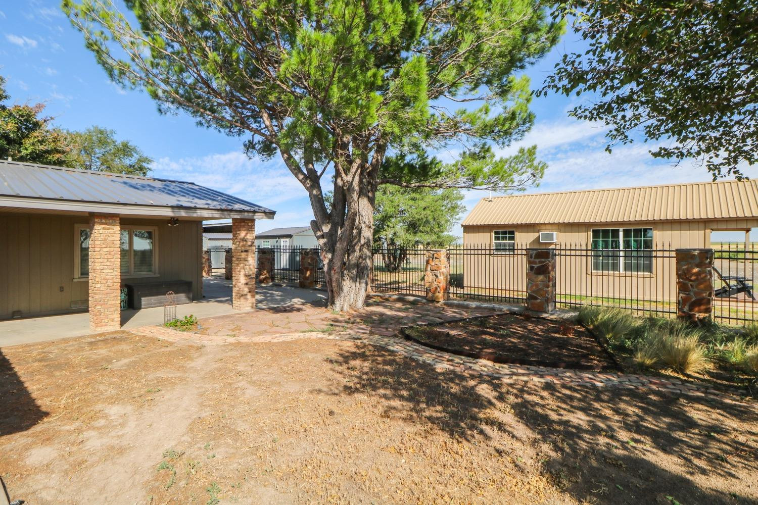 311 County Road 74 Muleshoe, TX 79347 - Photo 30 of 39 a front view of a house with a yard and potted plants
