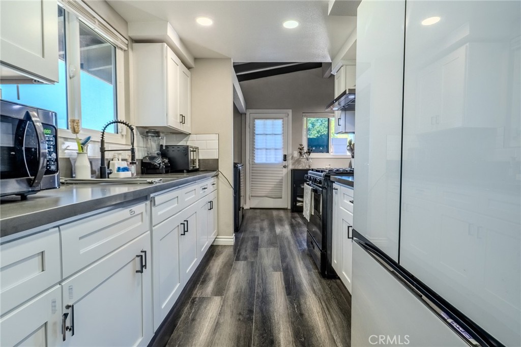 827 South Riverside Avenue Rialto, CA 92376 - Photo 11 of 60 a kitchen with stainless steel appliances sink stove microwave and cabinets