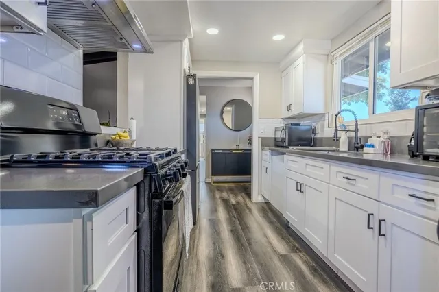 a kitchen with stainless steel appliances granite countertop a stove a refrigerator and a sink