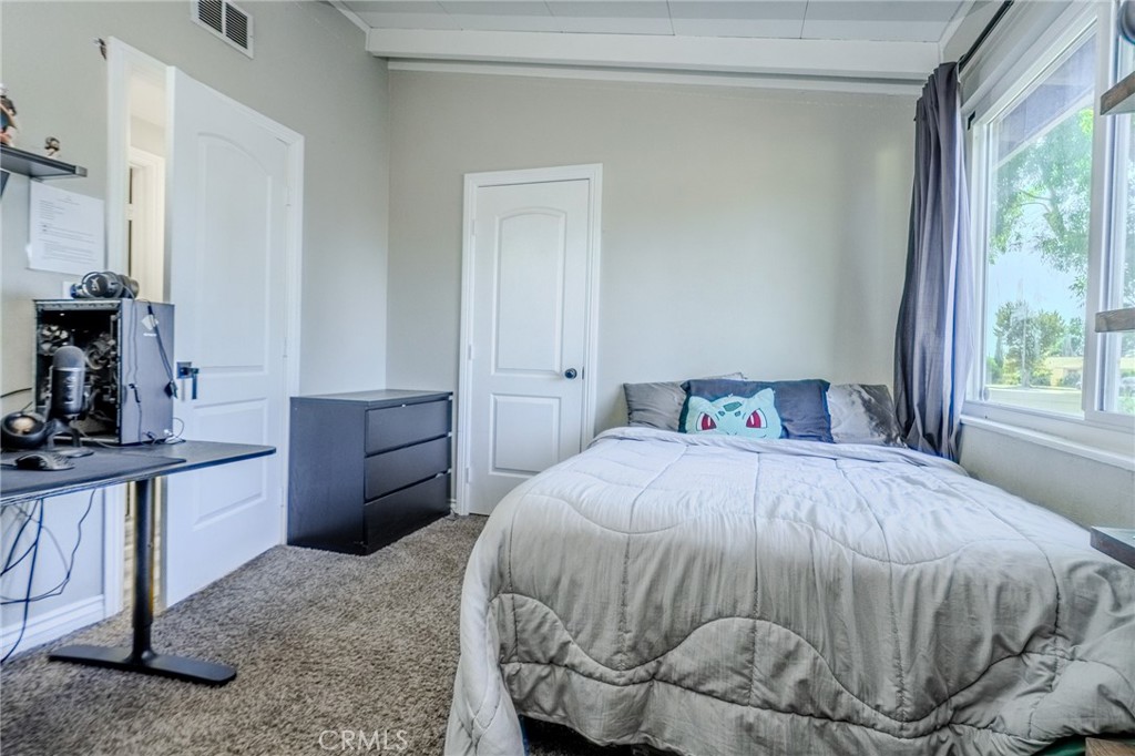 827 South Riverside Avenue Rialto, CA 92376 - Photo 16 of 60 a bedroom with a bed and a window