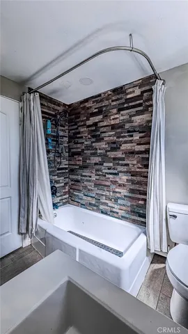 a bedroom with a bed a table and large windows