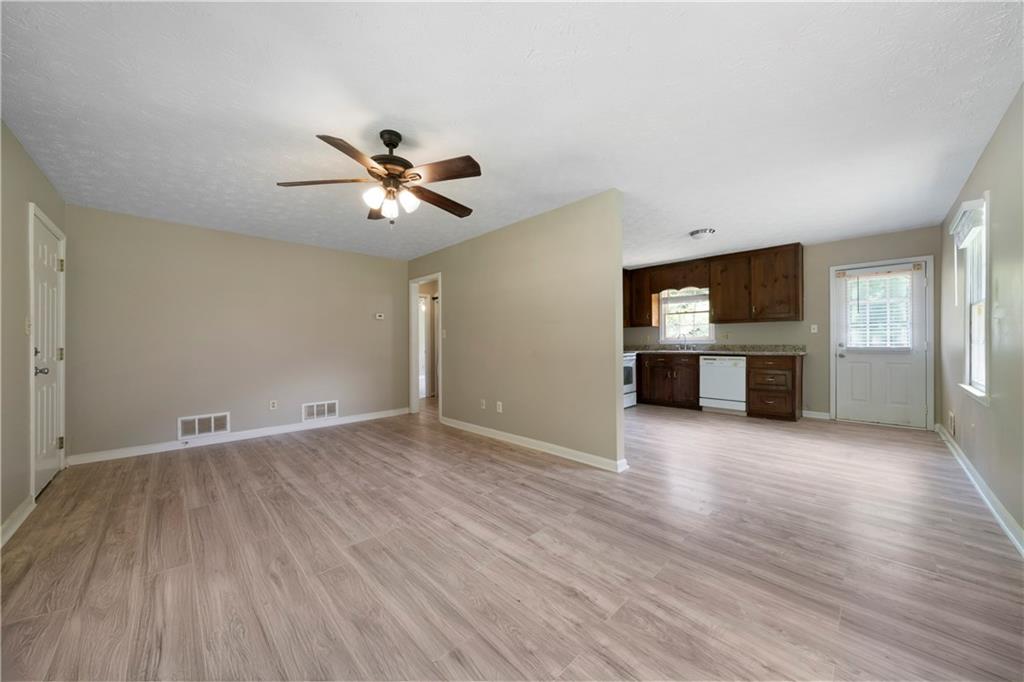 256 Powder Springs Street, Unit A Hiram, GA 30141 - Photo 5 of 16 an empty room with wooden floor a fireplace and windows